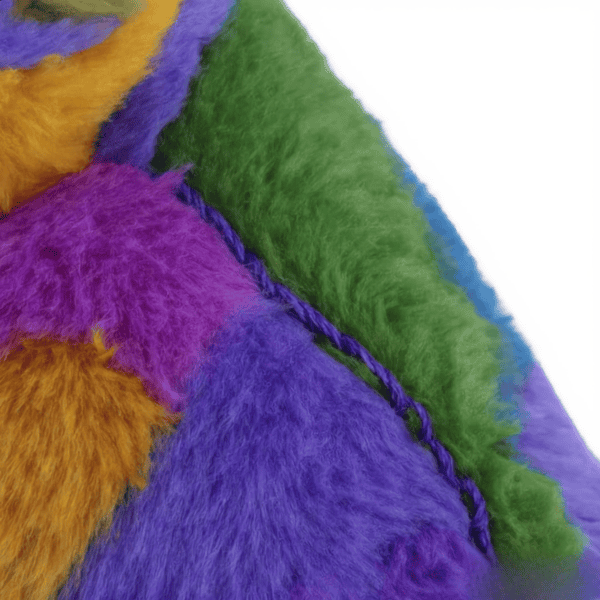 Close-up van de zachte poot van een multikleurige Stitch pluche knuffel.