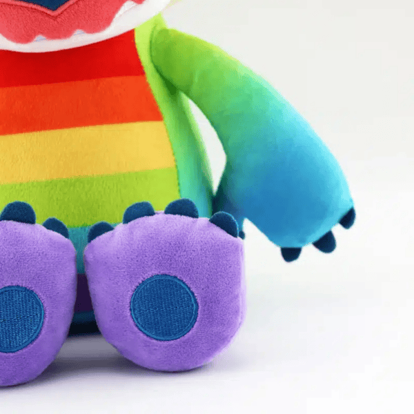Gedetailleerde close-up van de blauwe poot van een Stitch Pride knuffel.